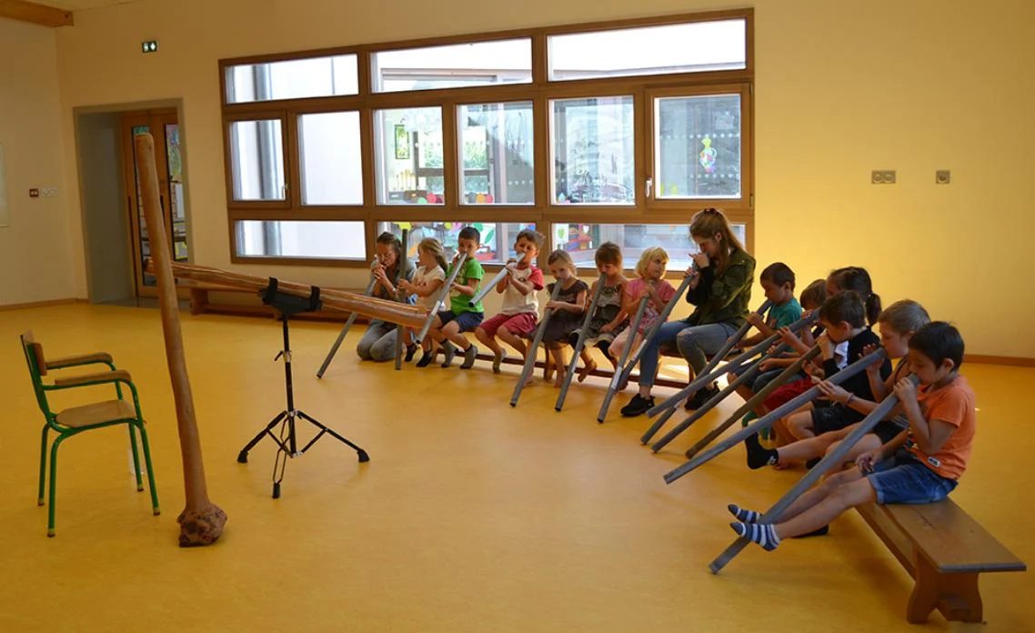 Groupe d'enfants découvrant le didgeridoo avec Mitch