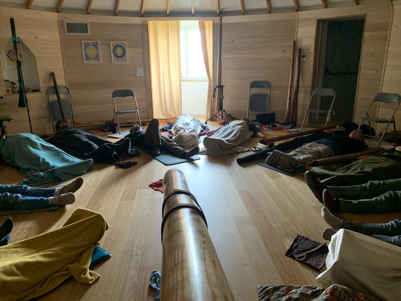 Voyage sonore au didgeridoo en groupe : les voyageurs allongés écoutent le didgeridoo